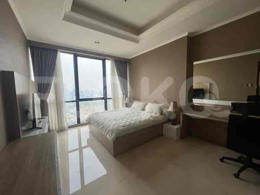 Another bedroom with a large bed, and a smart TV with a desk.