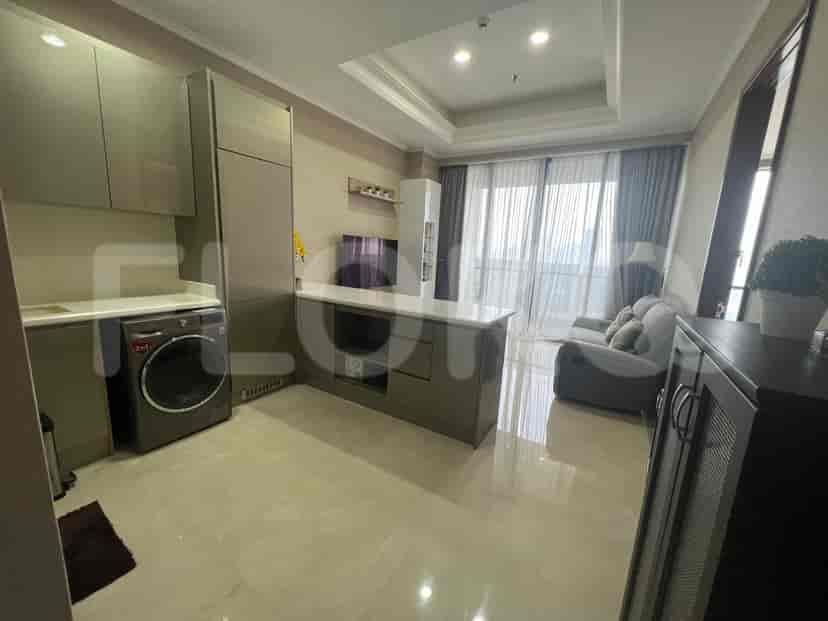 Open-plan living space featuring a kitchen, a sofa, and a tv.