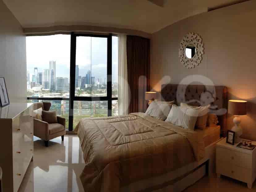Bedroom with a king bed and city view with a dresser and an armchair.
