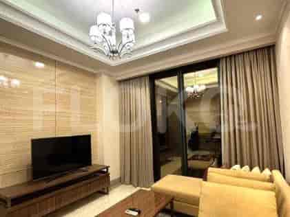 A modern living room with a TV, chandelier, and access to a balcony.