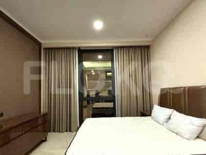 A bedroom featuring a bed, window with curtains, and a simple decor.