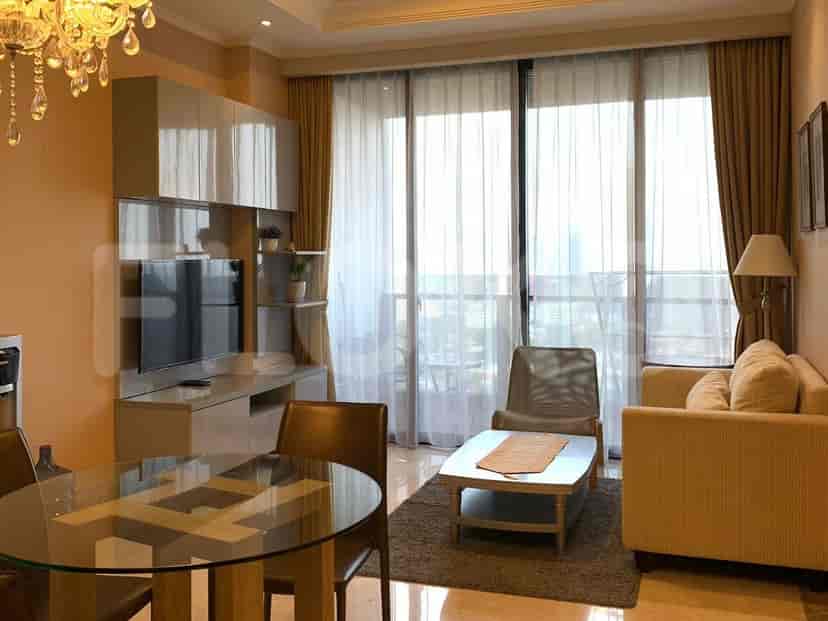A living room with a glass table, TV, and balcony access.