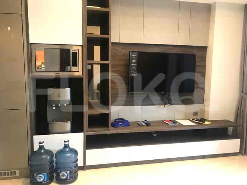 Living area with a wall-mounted TV, storage cabinets, and a water dispenser.