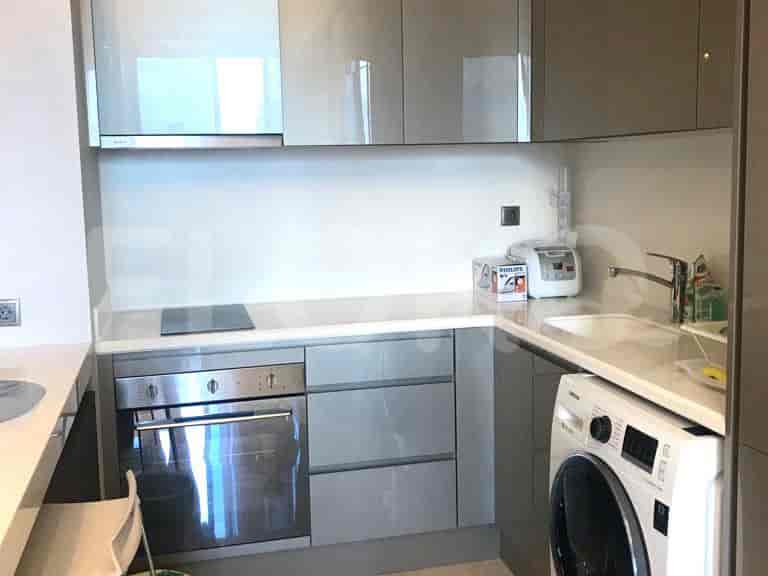 A modern kitchen with cabinets, an electric stove, and a washing machine.