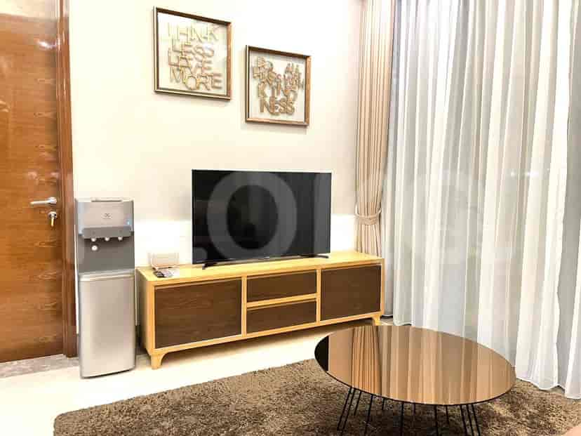 A modern living room with a TV, wooden cabinet, and a coffee table.