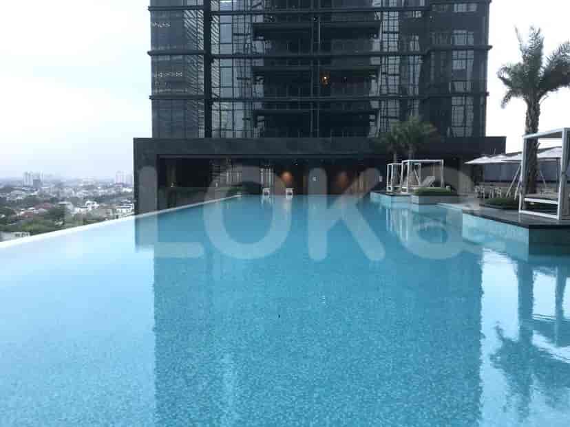 An outdoor swimming pool with a view of the city.