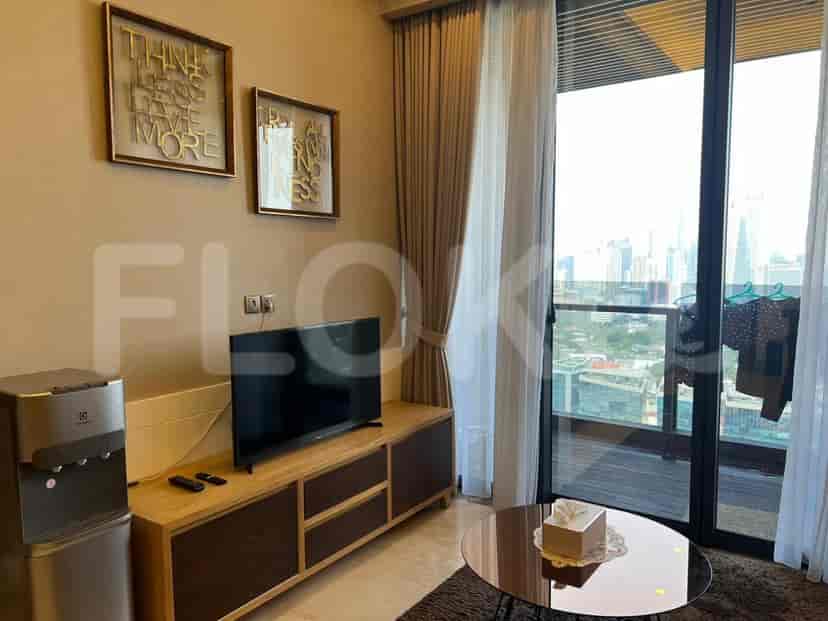 A living room with a TV, water dispenser, and decor.