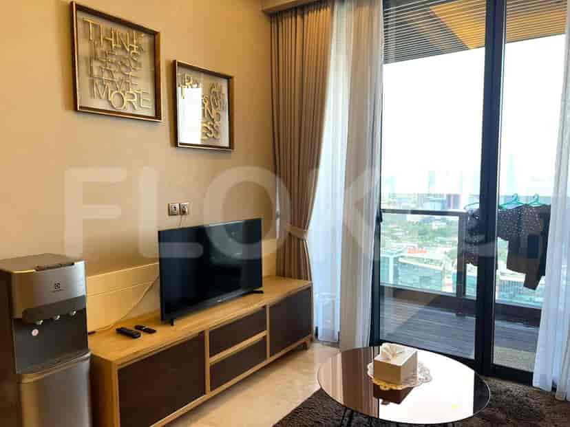 Living room with TV, water dispenser, and artwork.