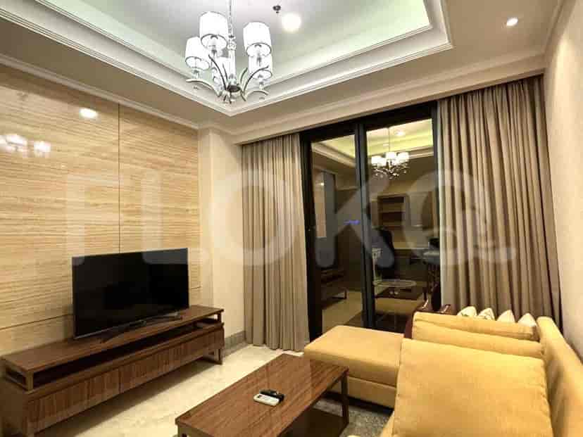 Living room with a TV, sofa, coffee table, and a sliding door leading to the outside.