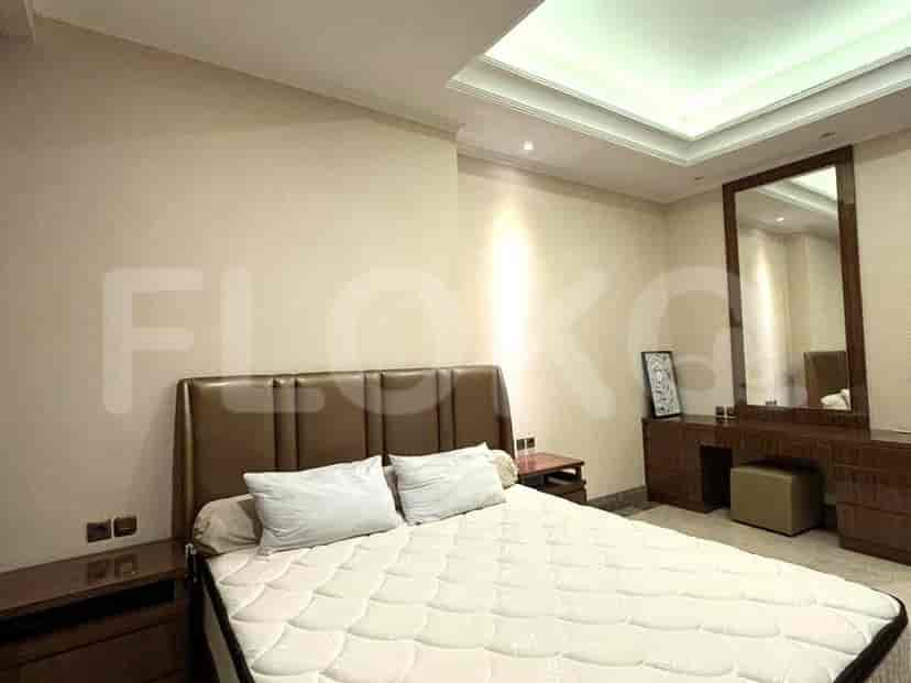 A bedroom with a bed, dresser, mirror, and a small stool.