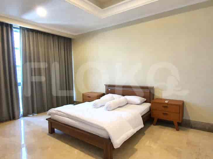A clean bedroom with a bed, two nightstands, and a large window.
