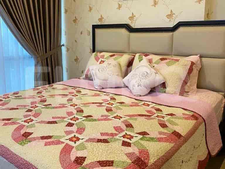 Cozy bedroom with a double bed, patterned quilt, and decorative pillows.