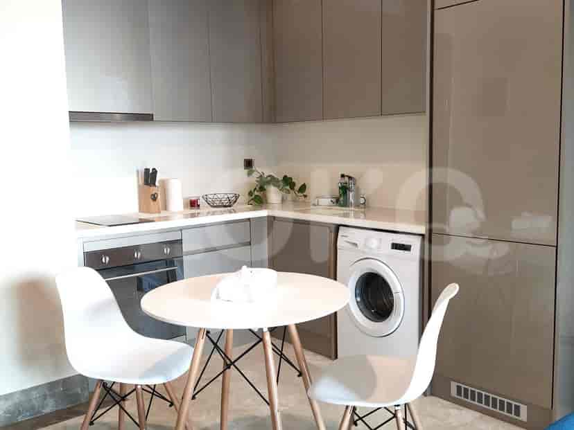 Kitchen with white chairs, dining table, and built-in appliances.