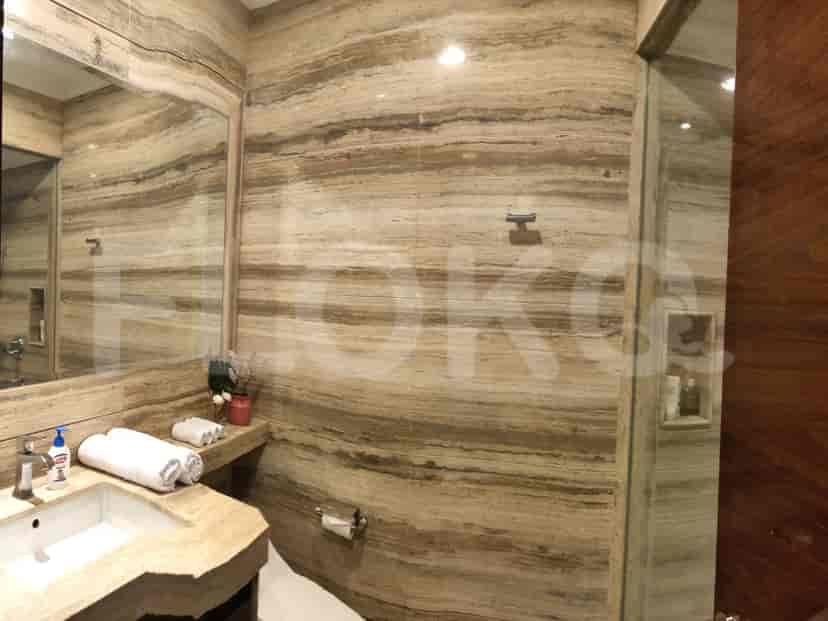 Luxurious bathroom with a marble backsplash, vanity, and a glass-enclosed shower.
