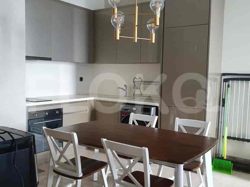 A modern kitchen featuring a dining table, cabinets, and appliances.