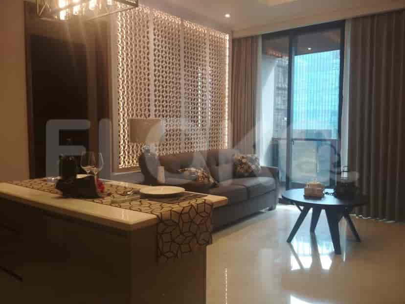 Ruang tamu dengan sofa, pulau dapur, dan balkon.