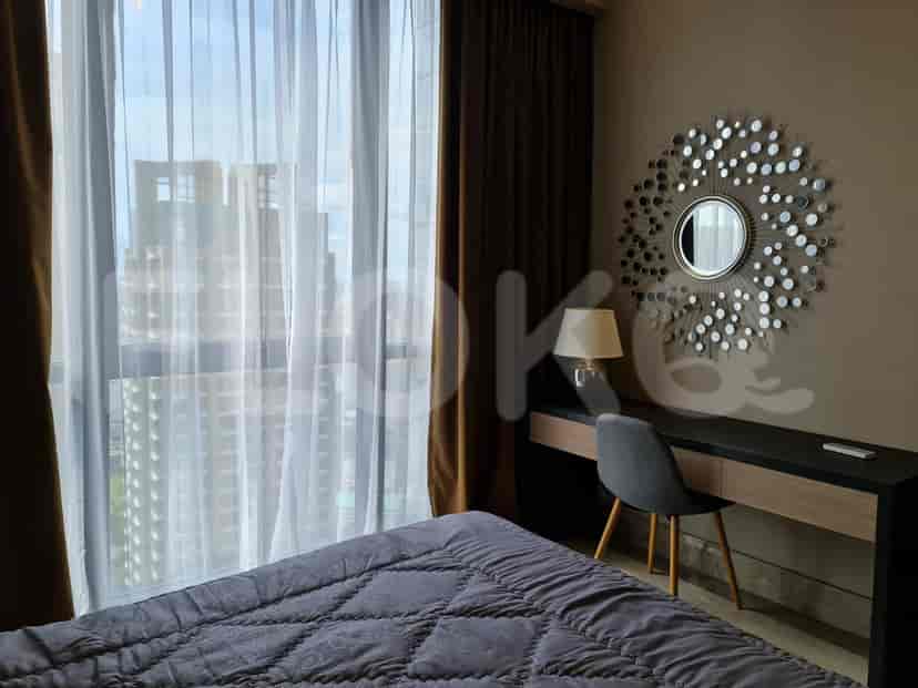 A bedroom with a bed, desk, and mirror.