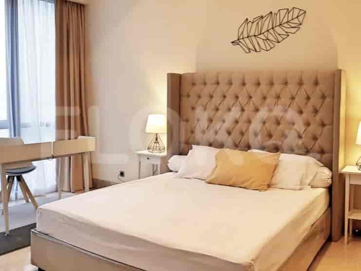 Kamar tidur dengan tempat tidur besar, kepala tempat tidur yang elegan, dan meja samping tempat tidur.