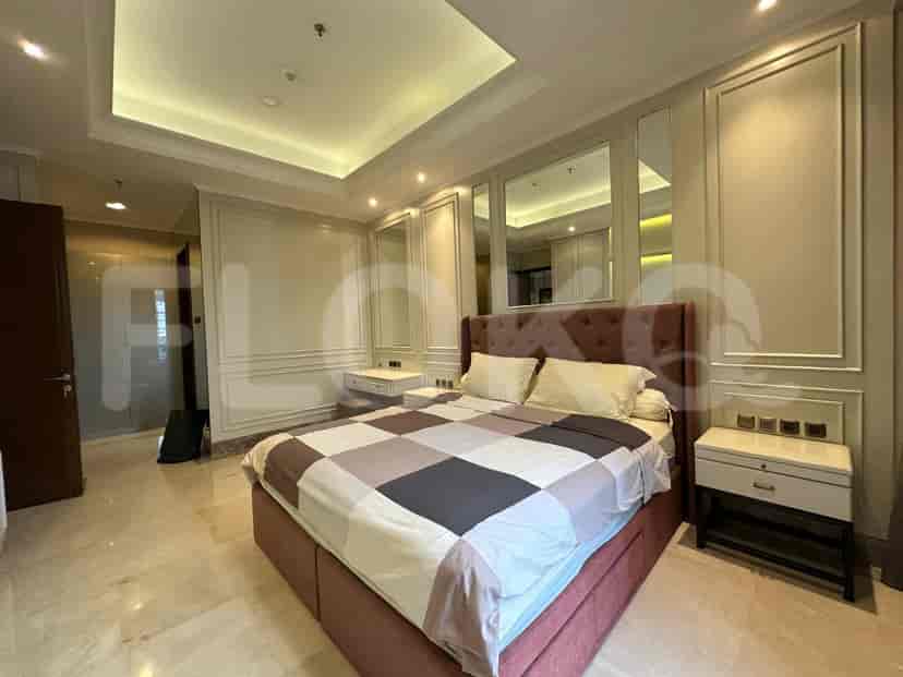 Bedroom with a bed, mirrors, and a vanity.