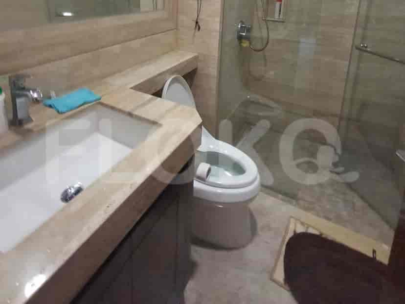 Bathroom with a marble-tiled wall and sink.