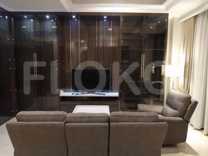 Ruang tamu mewah yang menampilkan pusat hiburan besar dengan penyimpanan built-in, sofa, dan kursi santai.