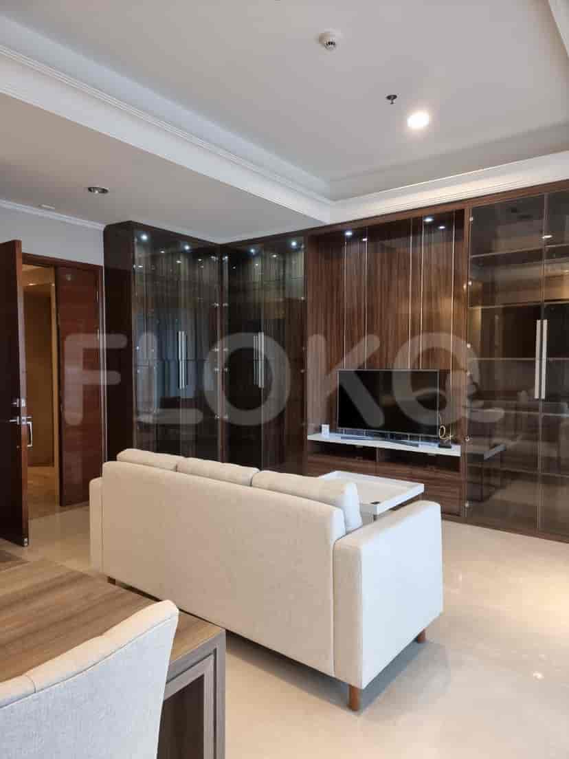 Ruang tamu yang menampilkan sofa modern, pusat hiburan, dan pemandangan area makan.