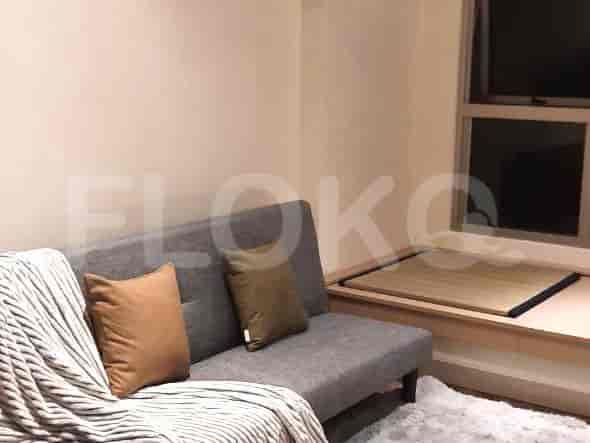 Modern living room featuring a grey sofa with pillows and a window.