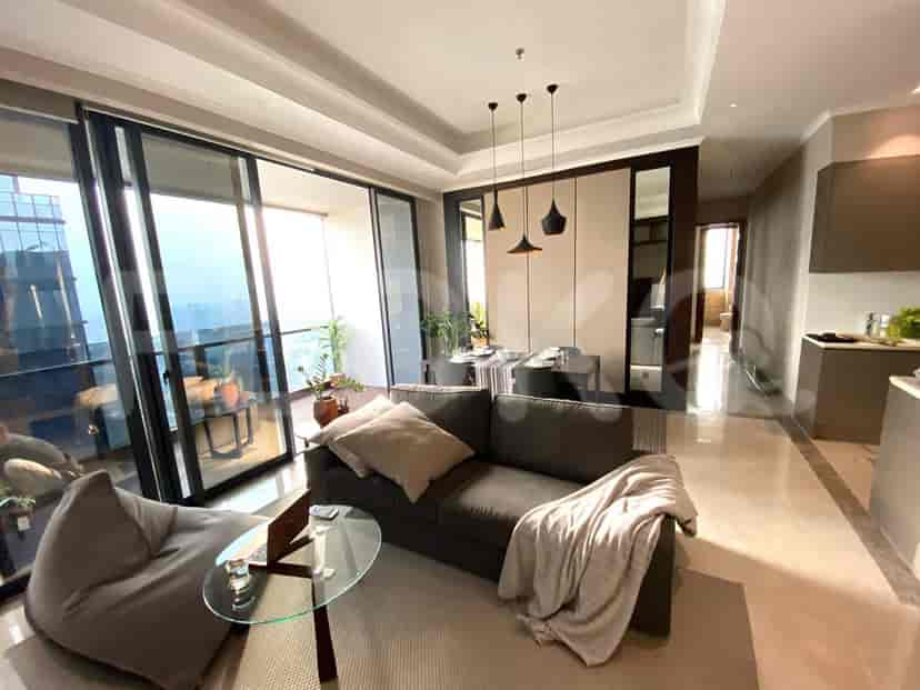 Modern living room with a grey sofa, glass coffee table, and balcony access.