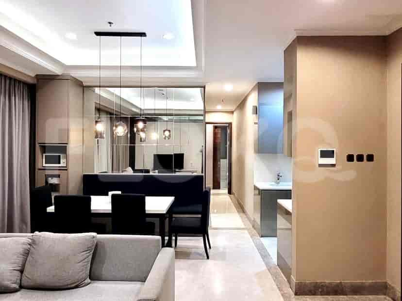 Modern dining area with a white dining table, black chairs, and a kitchen in the background.