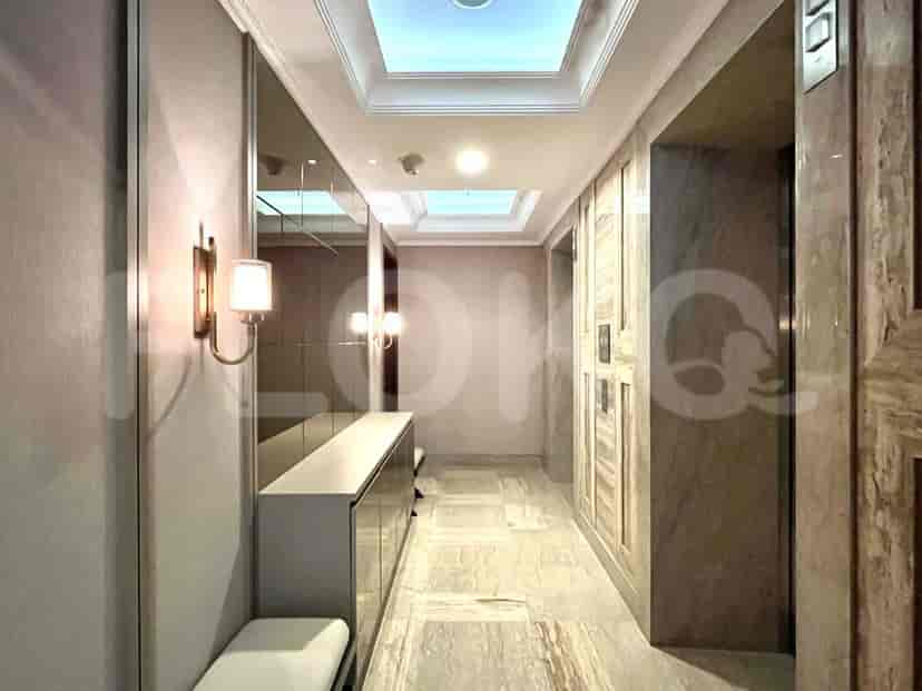 A hallway in a modern apartment with marble floors and decorative lighting.
