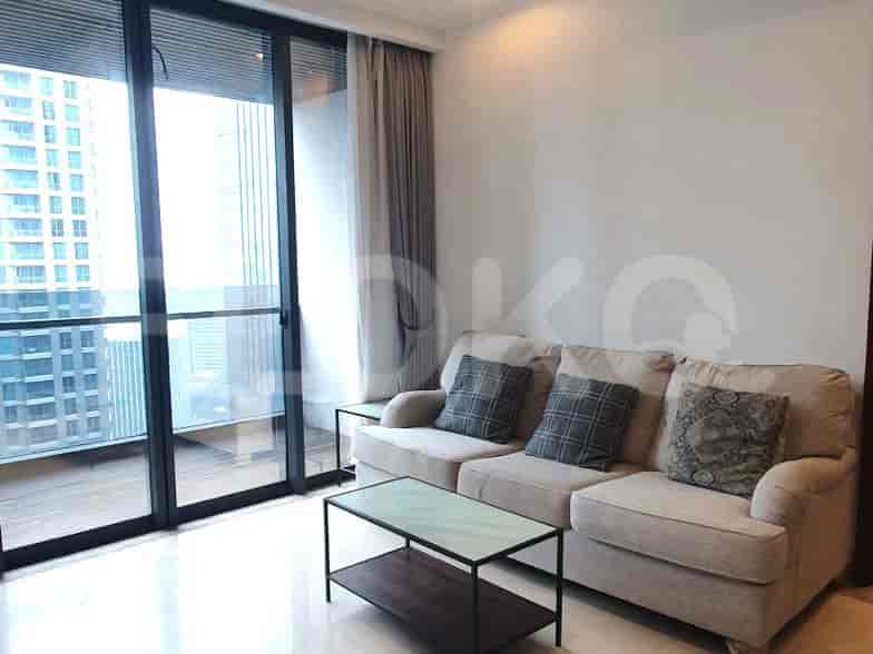 Ruang tamu modern dengan sofa abu-abu, meja kopi kaca, dan jendela besar yang menghadap ke kota.