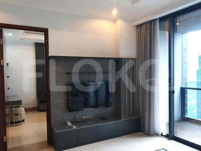 Ruang tamu dengan TV yang dipasang di dinding dan pemandangan balkon.