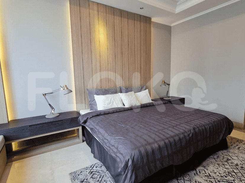 A bedroom featuring a large bed, bedside tables, and wooden accent wall.