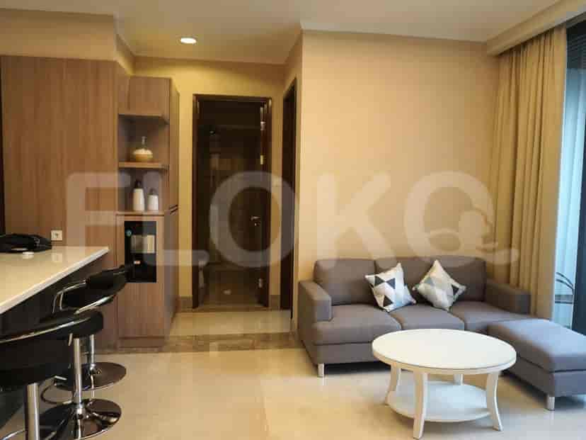 A cozy living space with a sectional sofa, a round coffee table, and a kitchen area.