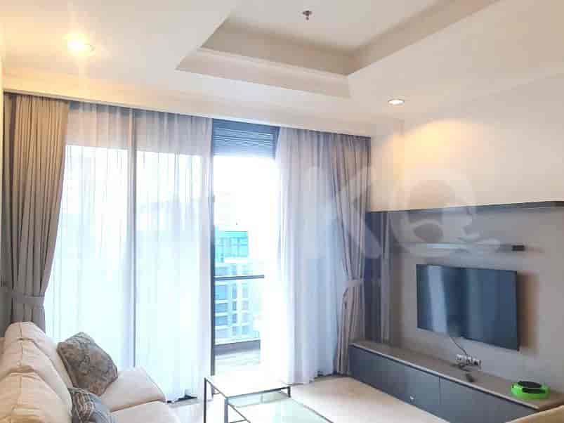 Living room with a mounted TV, sofa, and sheer curtains.