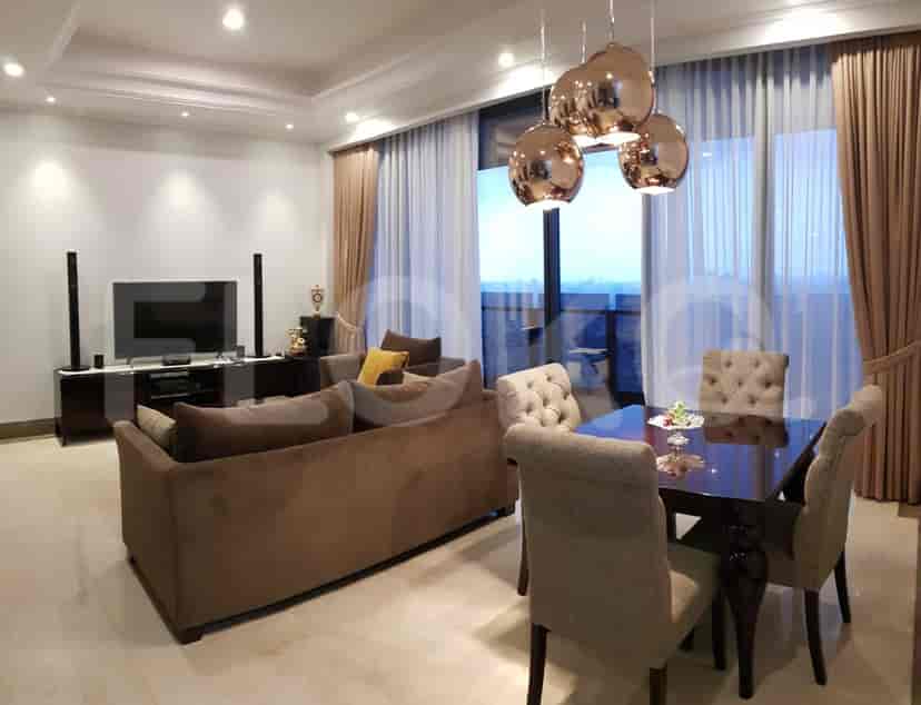 A luxurious living room with a large sofa, dining area, and a view through floor-to-ceiling windows.