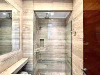 A modern bathroom with a walk-in shower and a large mirror.