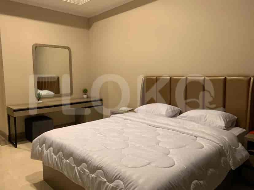 A bedroom with a bed, a dressing table, and a mirror.