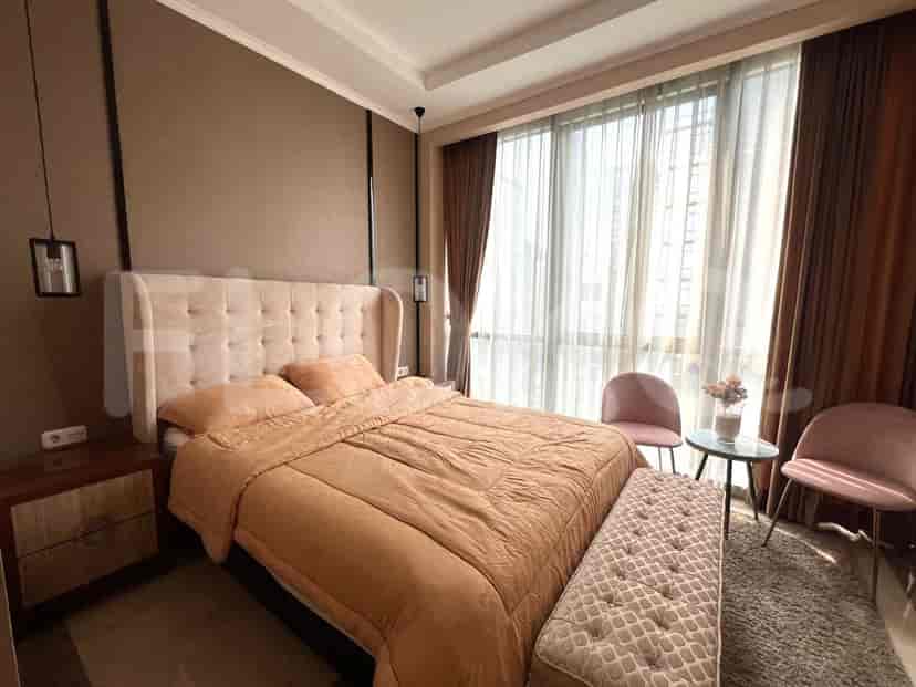 Bedroom with a king-sized bed, bedside table, and large windows.