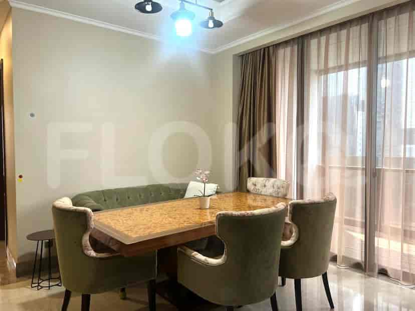 Dining area with a wooden table, green bench, and chairs.