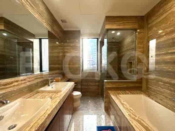 Luxurious bathroom featuring brown marble walls and flooring with bathtub.
