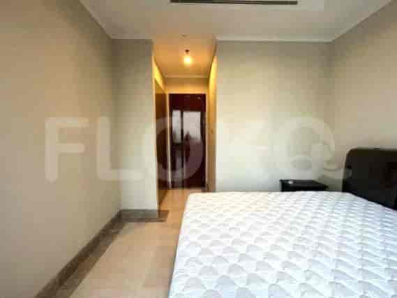 Bedroom with a white bed and doorway leading to hallway.