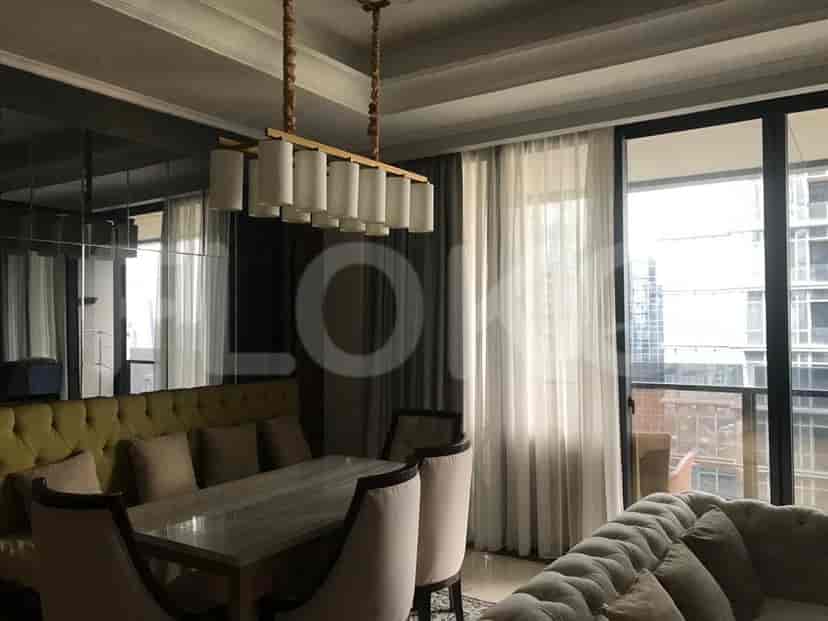A dining area with a dining table, chandelier, and view.