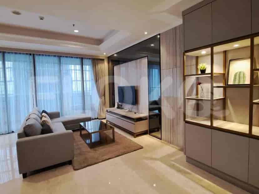 Ruang tamu modern dengan sofa abu-abu, TV, dan jendela besar.