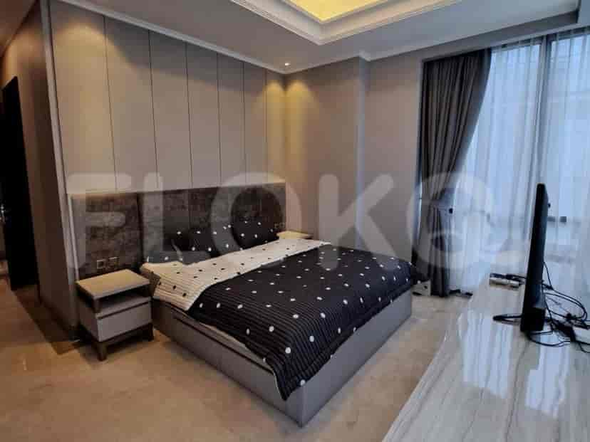 Kamar tidur utama yang elegan dengan tempat tidur ukuran king, meja samping tempat tidur, dan TV pintar.