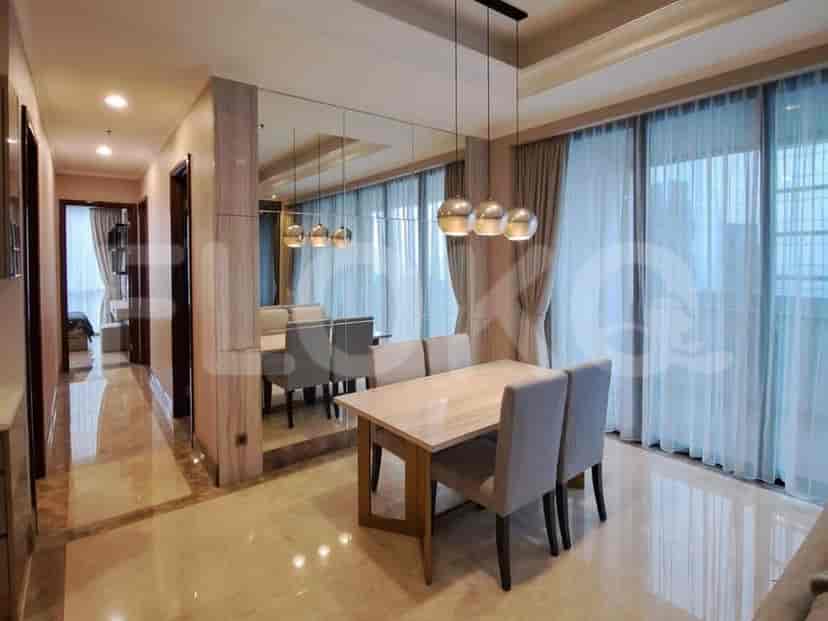 Area makan dengan meja, kursi, dan lampu gantung.