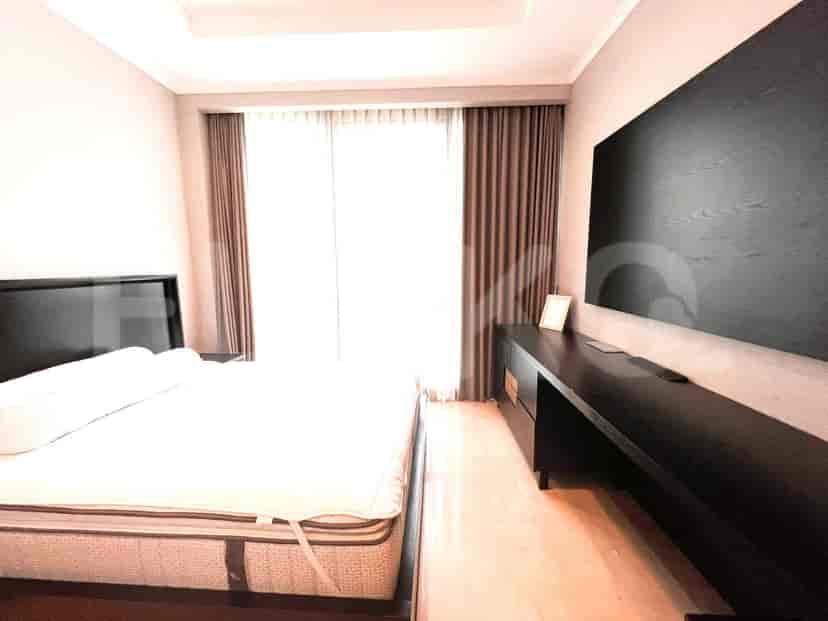 A bedroom featuring a king-sized bed, window with drapes, and a mounted TV.