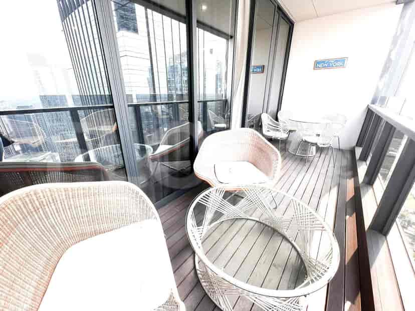 A balcony with a seating area overlooking the city.