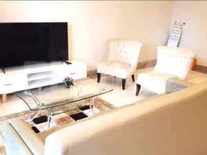 Living room with a dining table, sofa, and window with curtains.