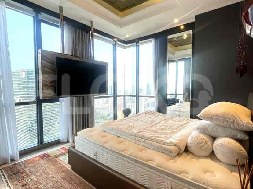 Luxurious bedroom with a king-sized bed, floor-to-ceiling windows, and a wall-mounted TV.
